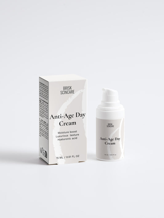 A white pump bottle of Anti-Age Day Cream with its packaging box behind it. The box has black text and the bottle has a white label with black text.