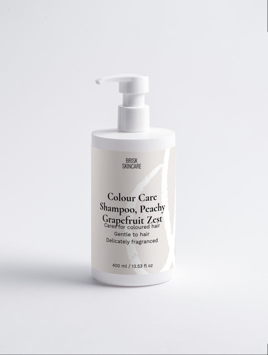 A white bottle of Colour Care Shampoo with a pump dispenser, labeled as Peachy Grapefruit Zest. The shampoo is designed for coloured hair and is delicately fragranced.