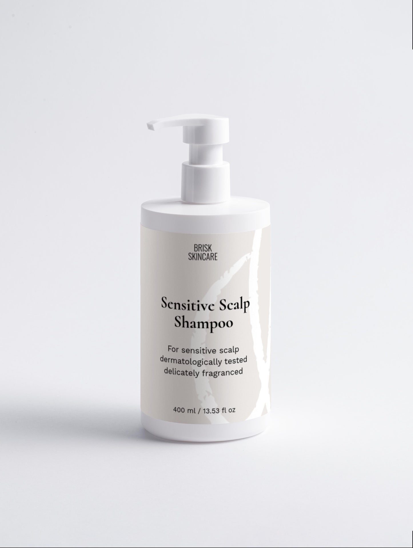A white pump bottle labeled Sensitive Scalp Shampoo designed for sensitive skin.