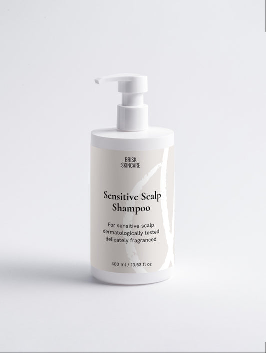 A white pump bottle labeled Sensitive Scalp Shampoo designed for sensitive skin.