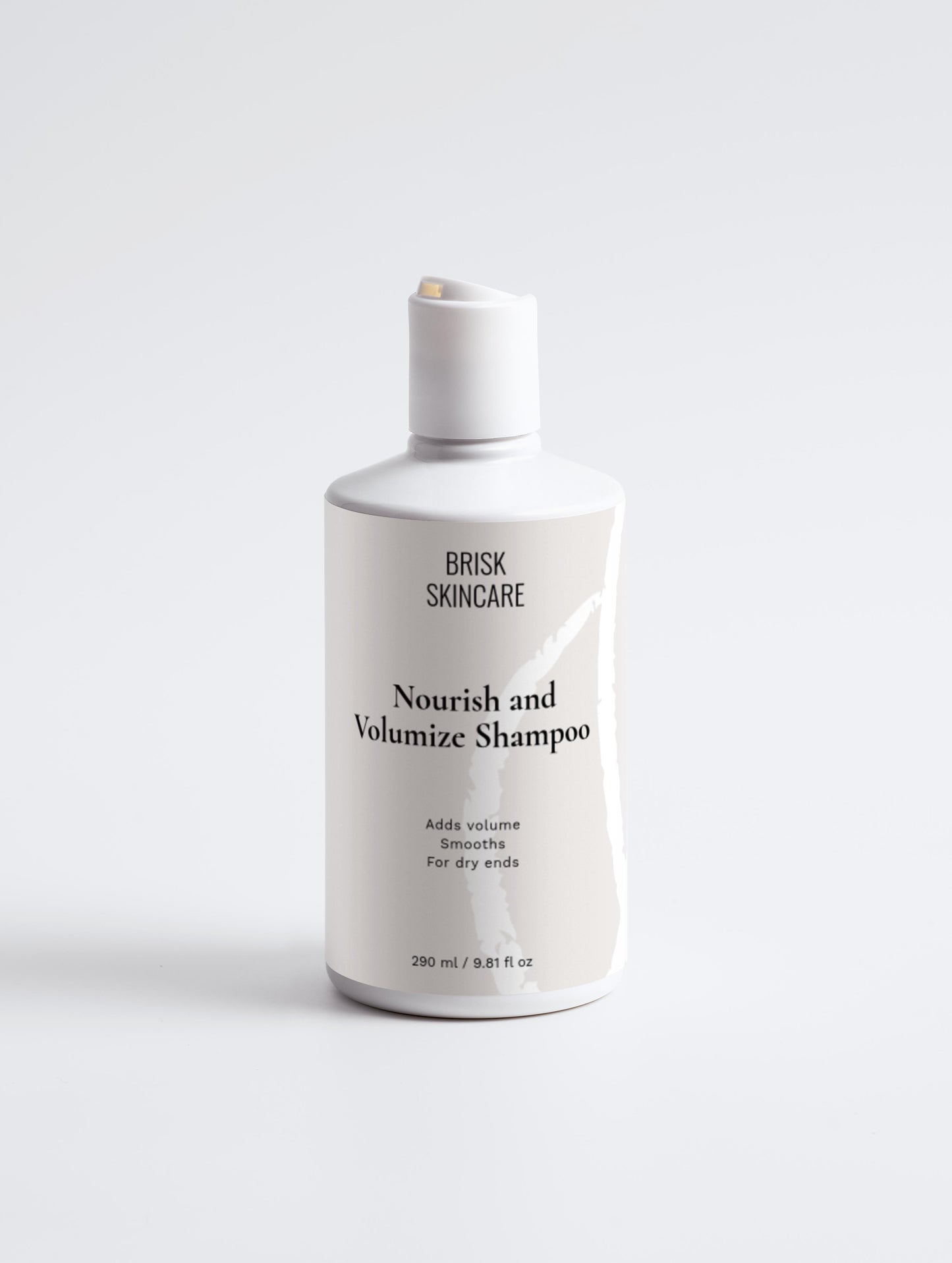 A white bottle of Nourish and Volumize Shampoo from BRISK SKINCARE with black and grey text, designed for hair care.