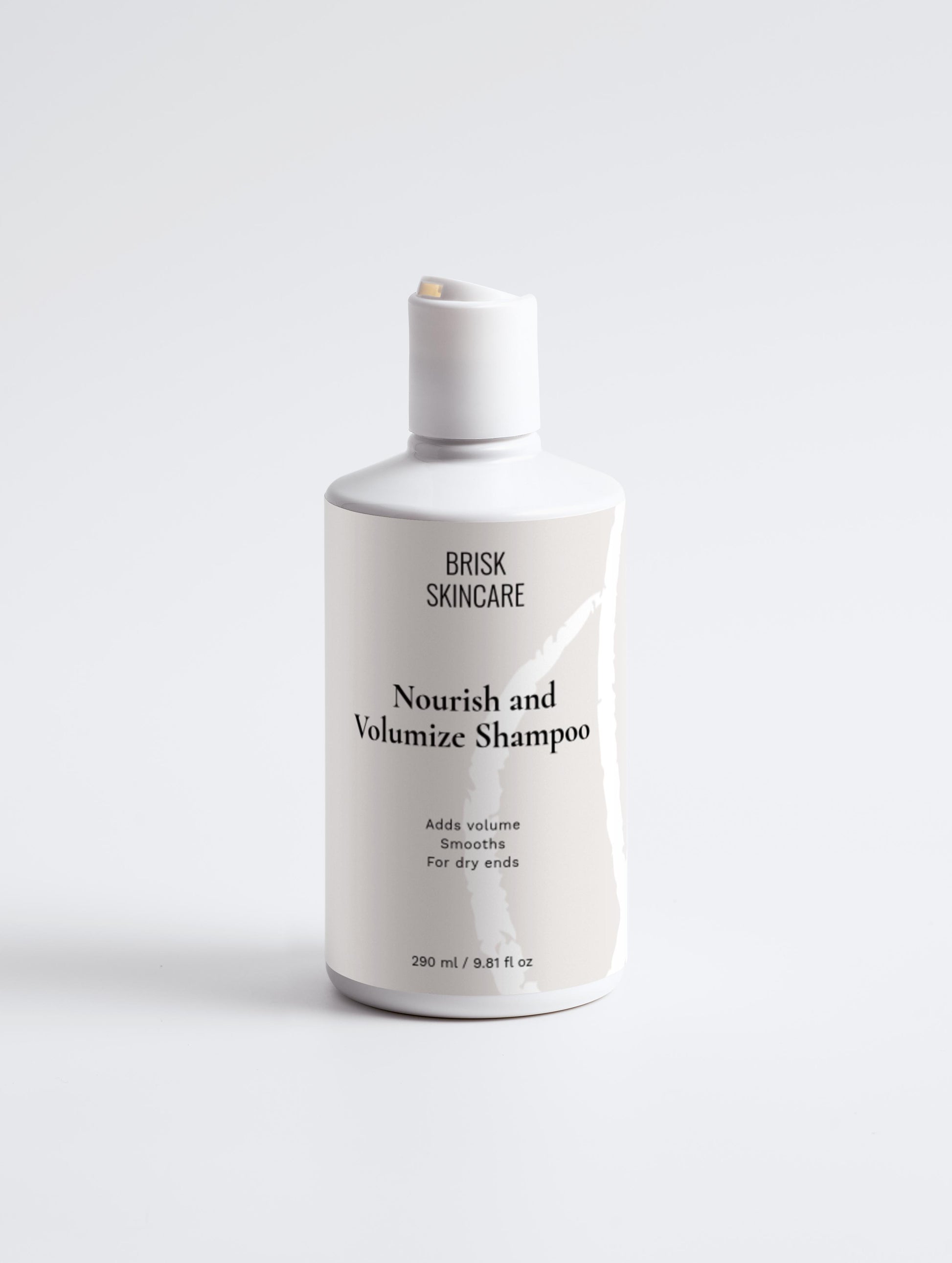 A white bottle of Nourish and Volumize Shampoo from BRISK SKINCARE with black and grey text, designed for hair care.