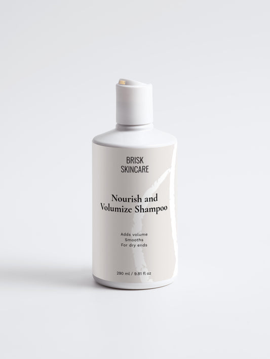 A white bottle of Nourish and Volumize Shampoo from BRISK SKINCARE with black and grey text, designed for hair care.